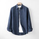 A blue shirt hanging on a white wall