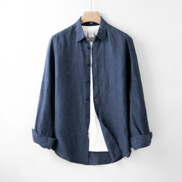A blue shirt hanging on a white wall